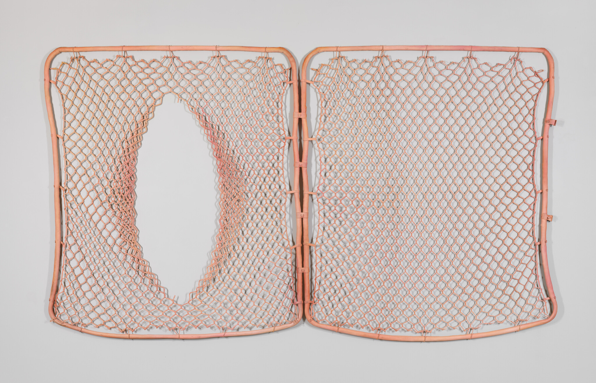 Two rectangular orange nets joined in the middle, with a large oval hole in the left net.