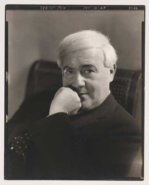 Older man with light hair rests his chin on his fist while looking toward the camera.