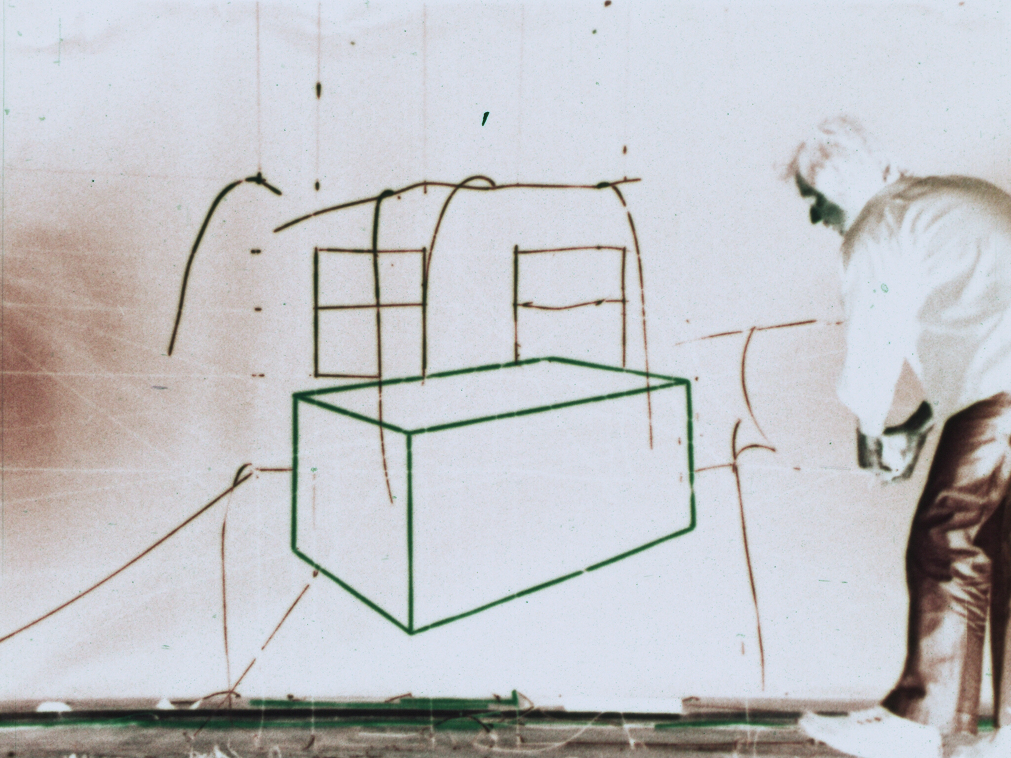 Man drawing a large green three-dimensional box and window sketches on a whiteboard.