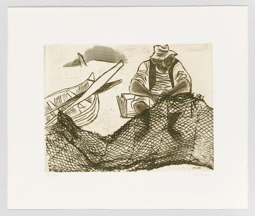 A fisherman sitting by a small boat mends a large fishing net on the shore.