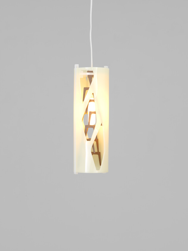 A glowing cylindrical pendant light hangs from a cord, showing decorative diagonal cutouts.