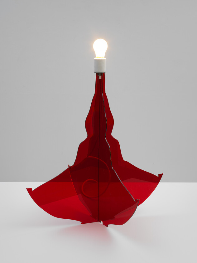 A lit light bulb sits atop an inverted red umbrella repurposed as a modern lamp.
