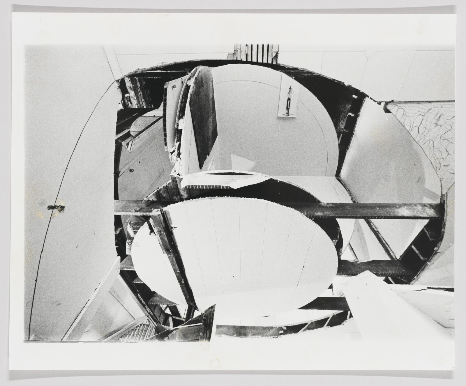 Circular ceiling cutouts reveal broken wooden beams and exposed structure above.