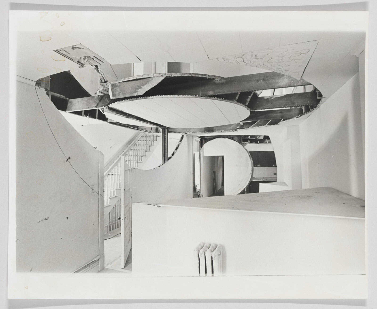 Room undergoing renovation with large circular ceiling openings and exposed structural beams.