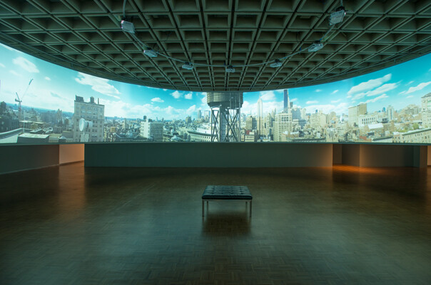 Empty gallery with a single bench facing a wide panoramic cityscape projection and water tower.