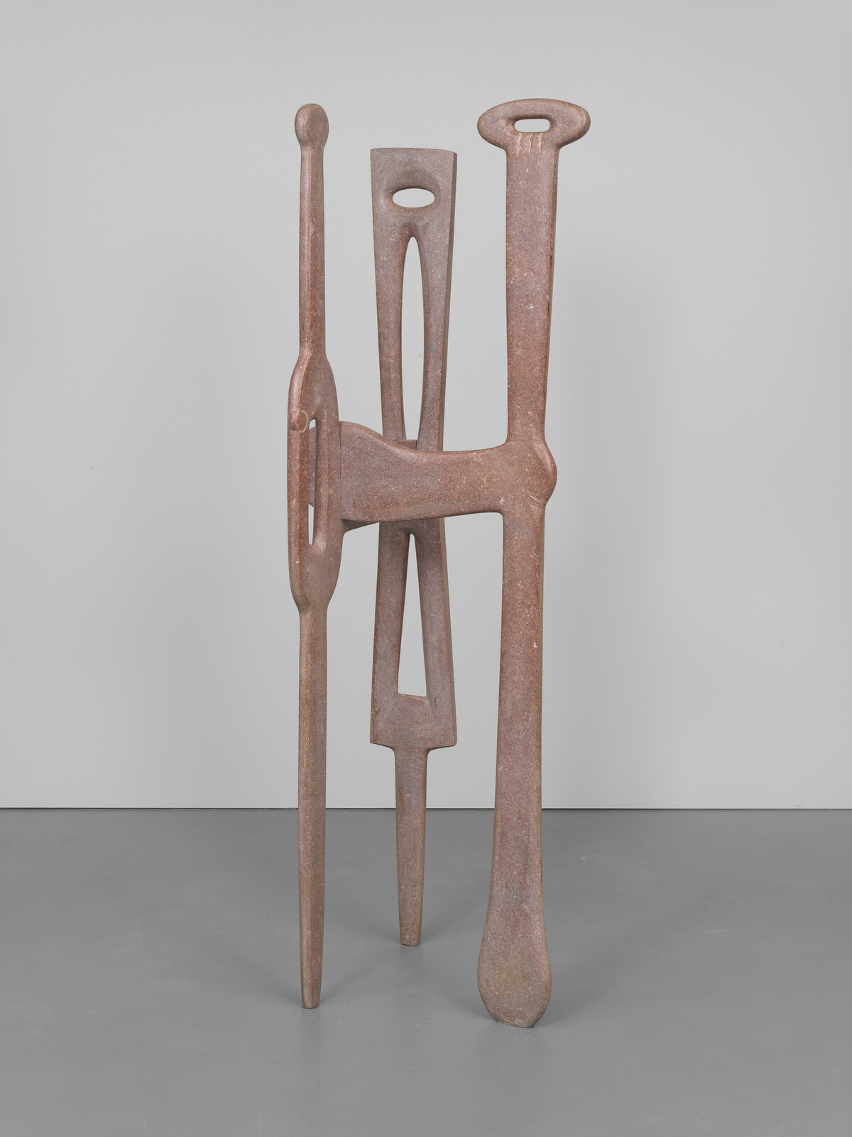 A warm monotone sculpture with an organic tripod formation, smooth and sinewy lines, and varied negative spaces.