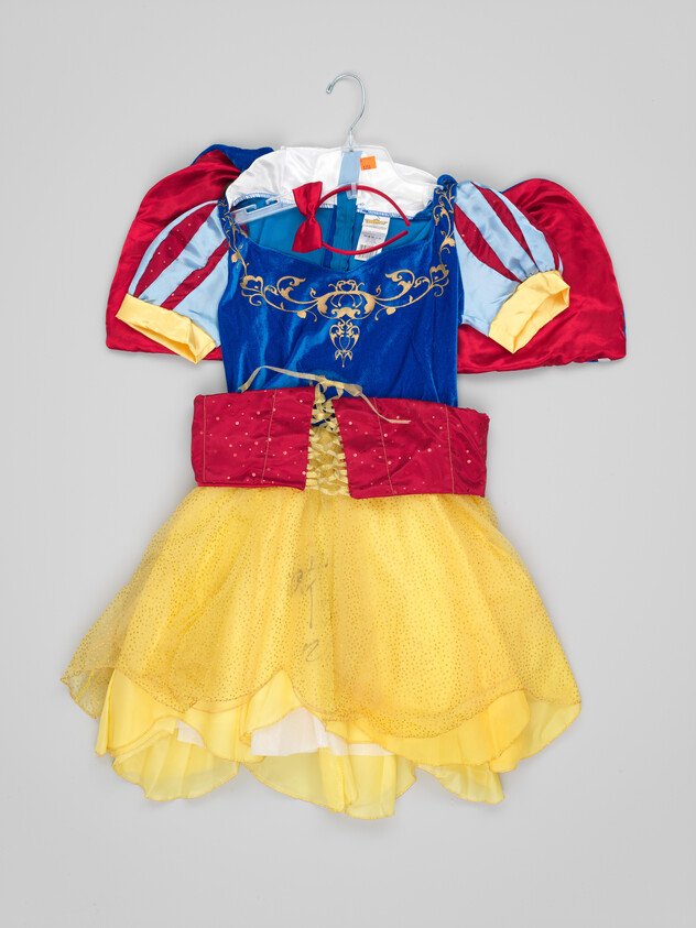 A child's Snow White–style costume dress with blue bodice, red puffed sleeves, and yellow skirt.