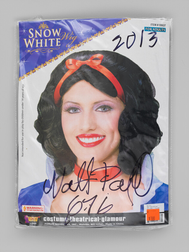 Snow White wig packaging showing model wearing black wig with red ribbon and price sticker.