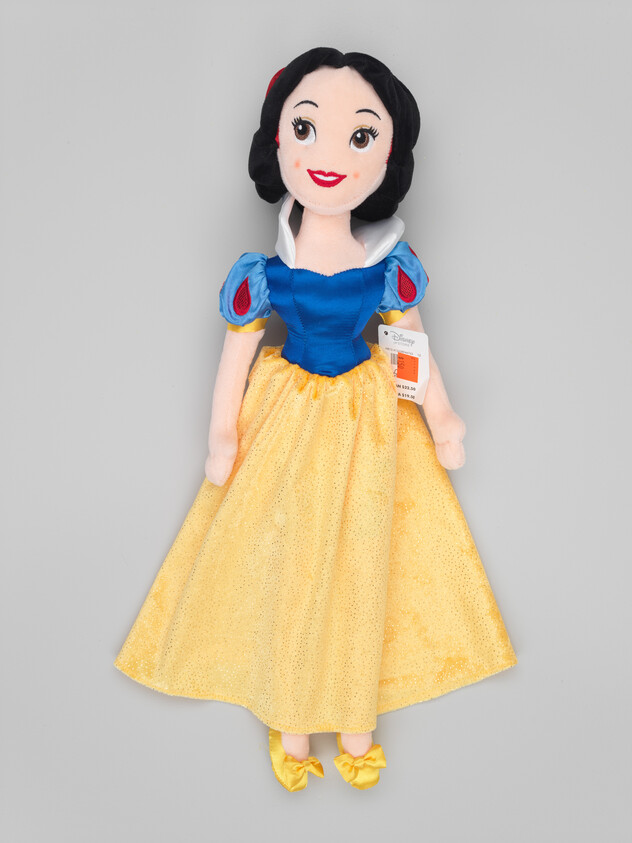 A plush Snow White doll with blue bodice, yellow skirt, and red hair bow.