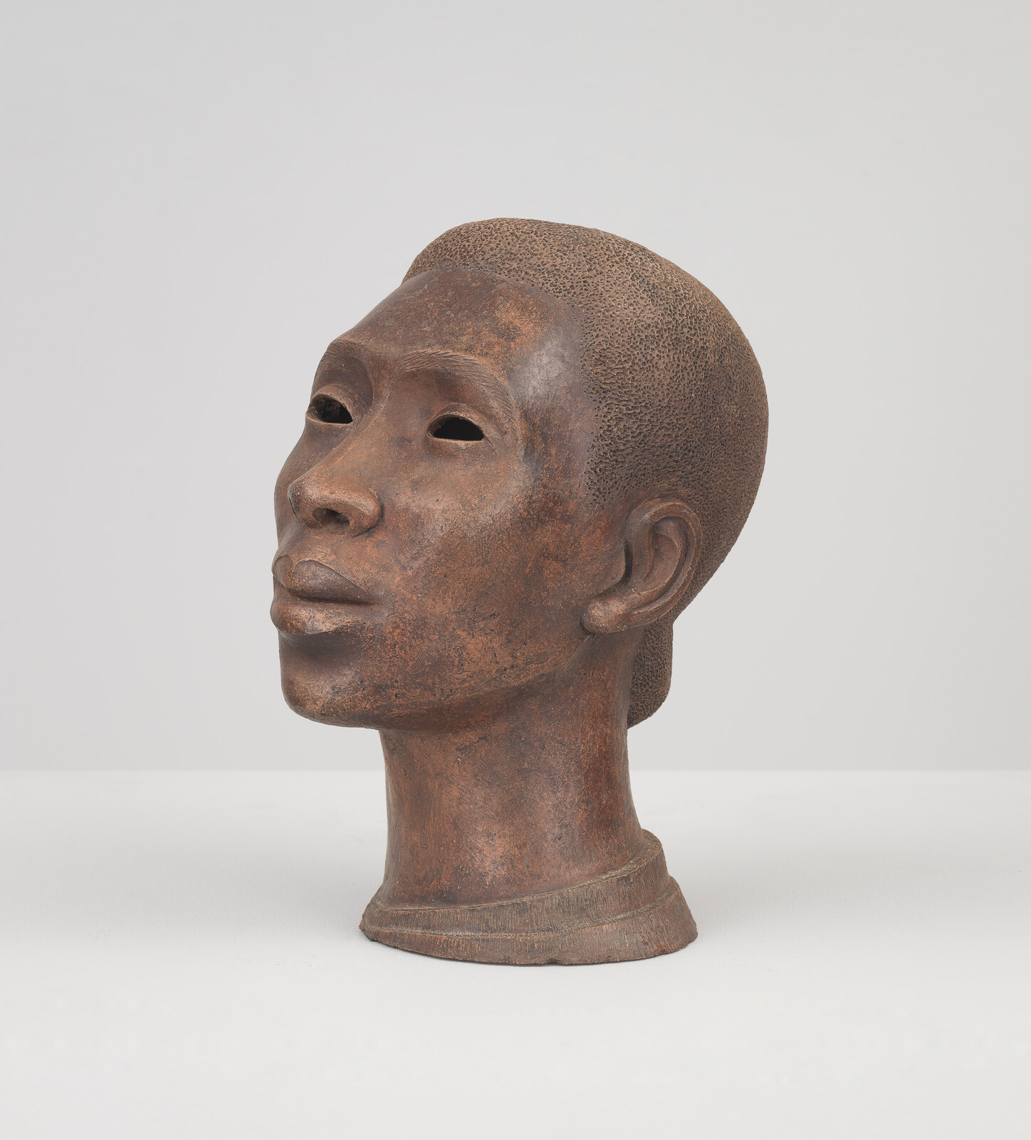 A portrait bust of a Black woman, her face lifted slightly towards the sky