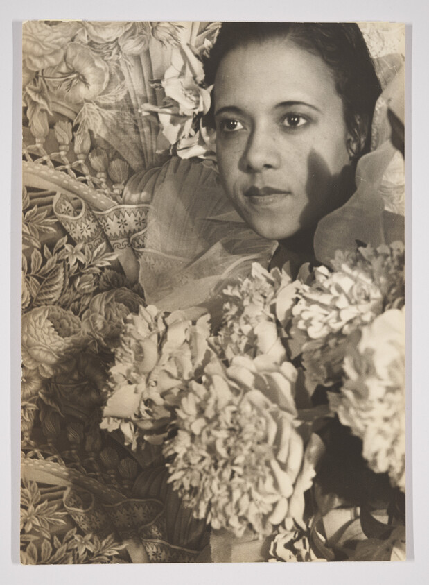 A sepia-toned photograph of a woman's face partially obscured by shadows and surrounded by floral patterns and blooms. Her expression is serene and contemplative.