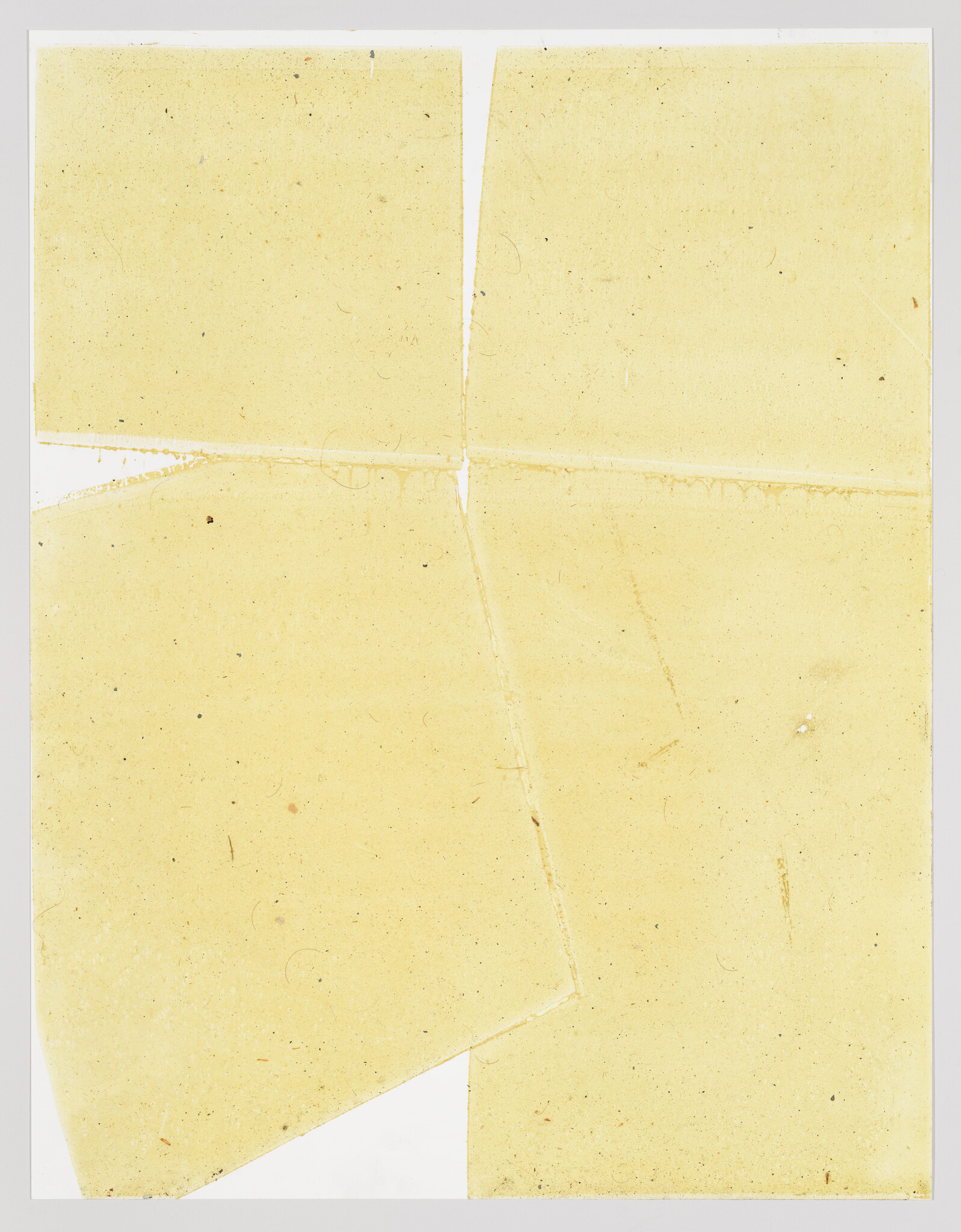 Yellowed torn paper pieces overlap with visible creases, stains, and small specks.