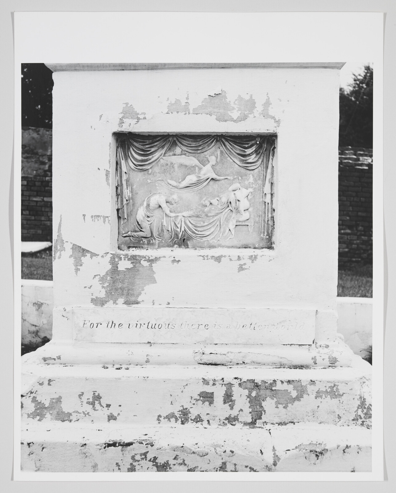 Worn stone monument with a bas-relief of reclining figures and the inscription "For the virtuous there is a better world."