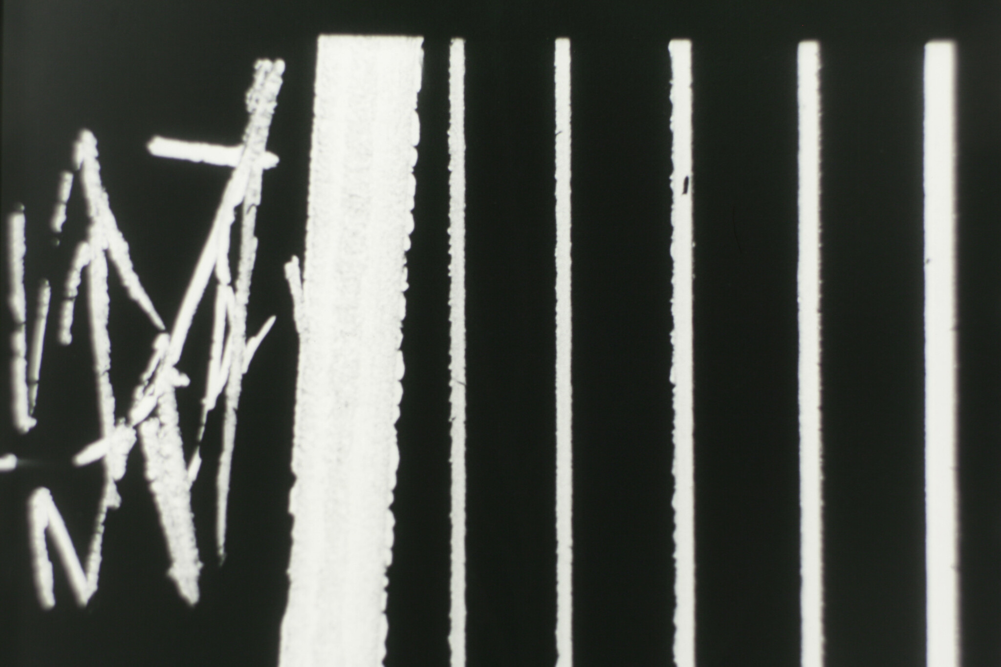 White vertical bars and scribbled chalk lines on a black background suggest abstract pattern.