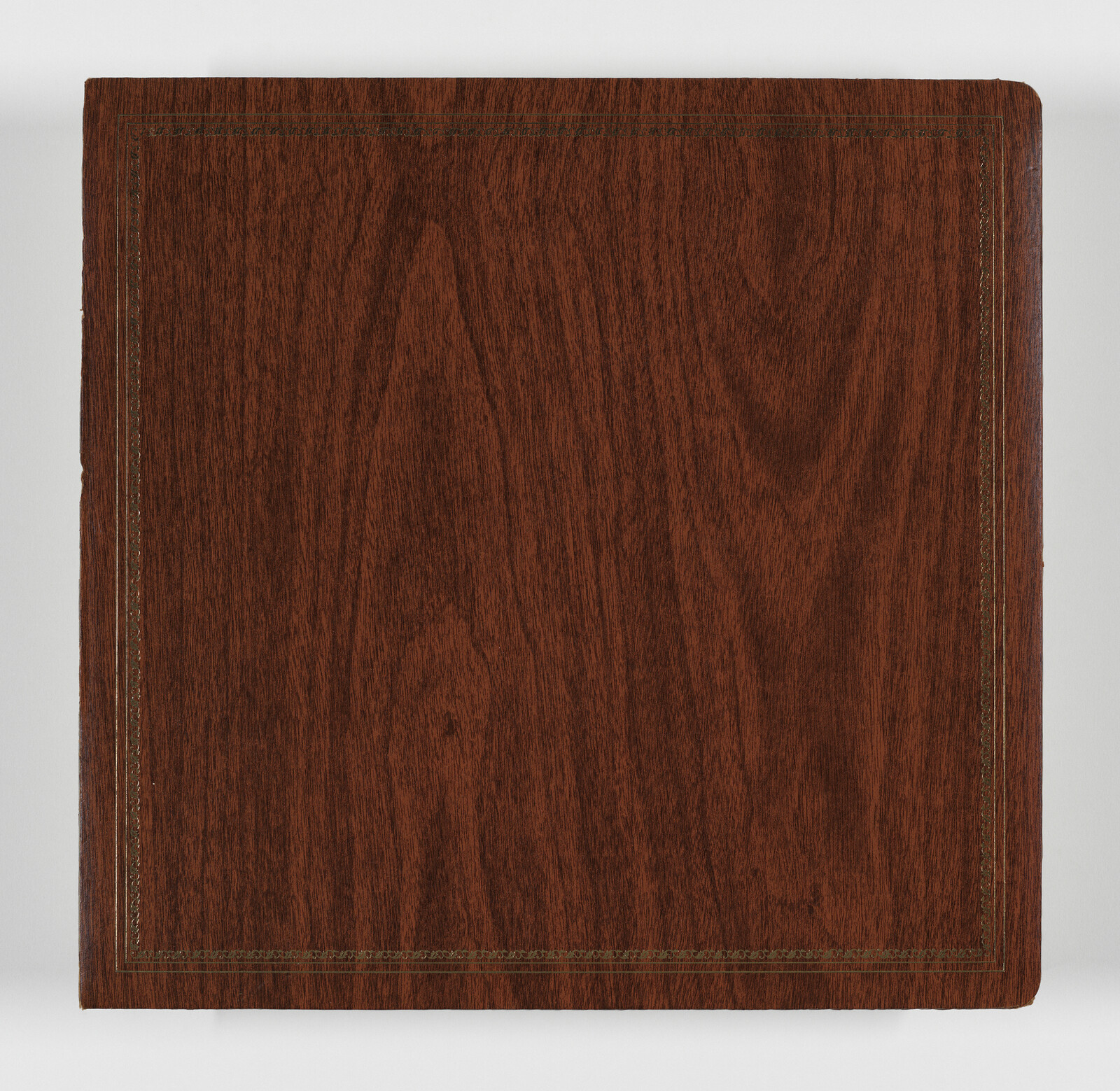 Square wooden photo album cover with decorative stitched border and rounded corner.