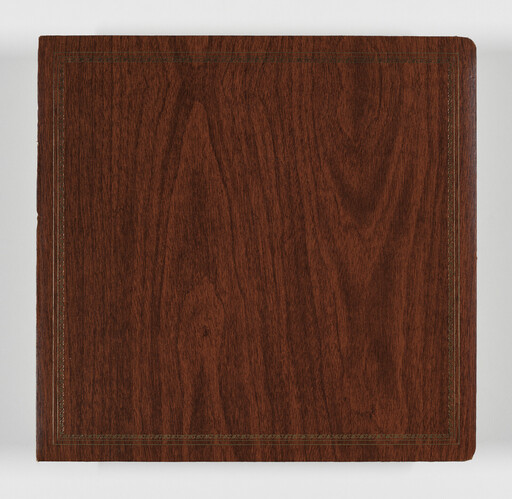 Square wooden photo album cover with decorative stitched border and rounded corner.