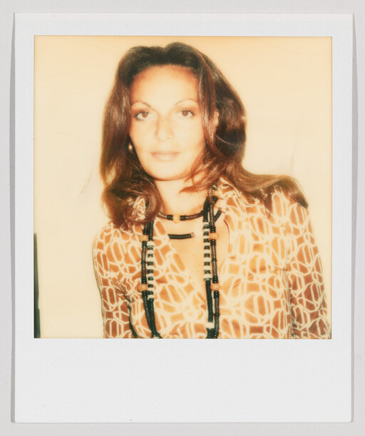 A woman wearing a patterned blouse and long beaded necklaces poses in a Polaroid-style portrait.