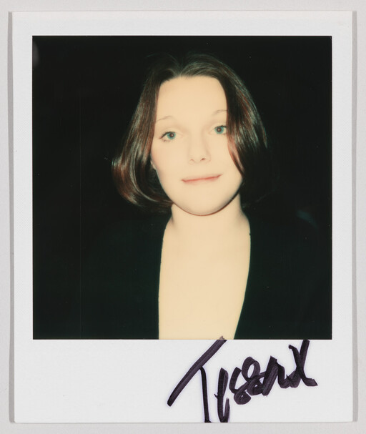 Young woman with short brown hair looks forward against a dark background.