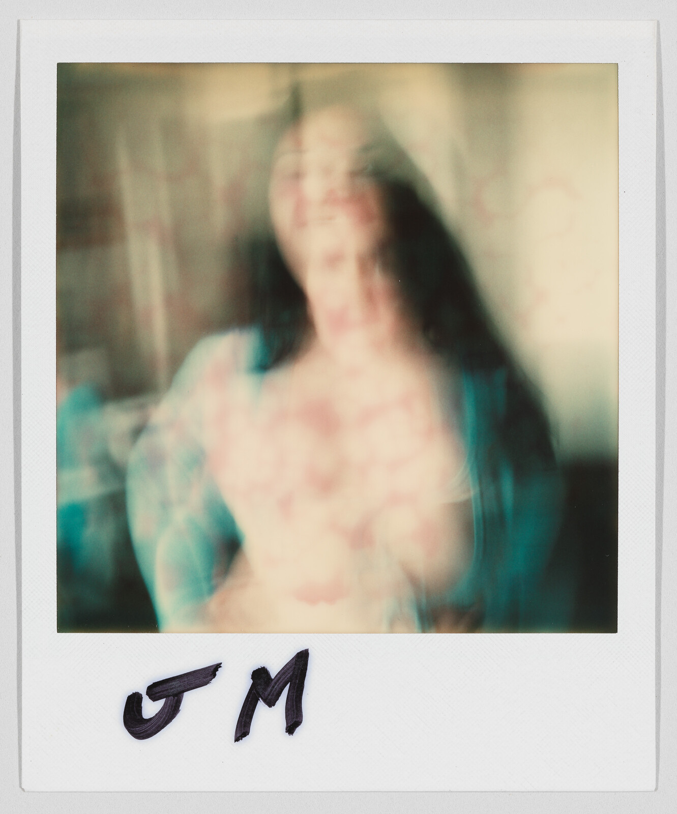 A blurry person stands facing the camera. The letters "J M" are written at the bottom.