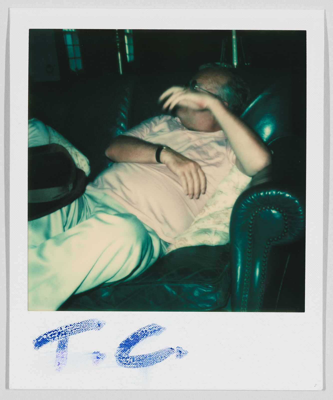 A man in light clothes rests on a dark couch, with “T.C.” written at the bottom.