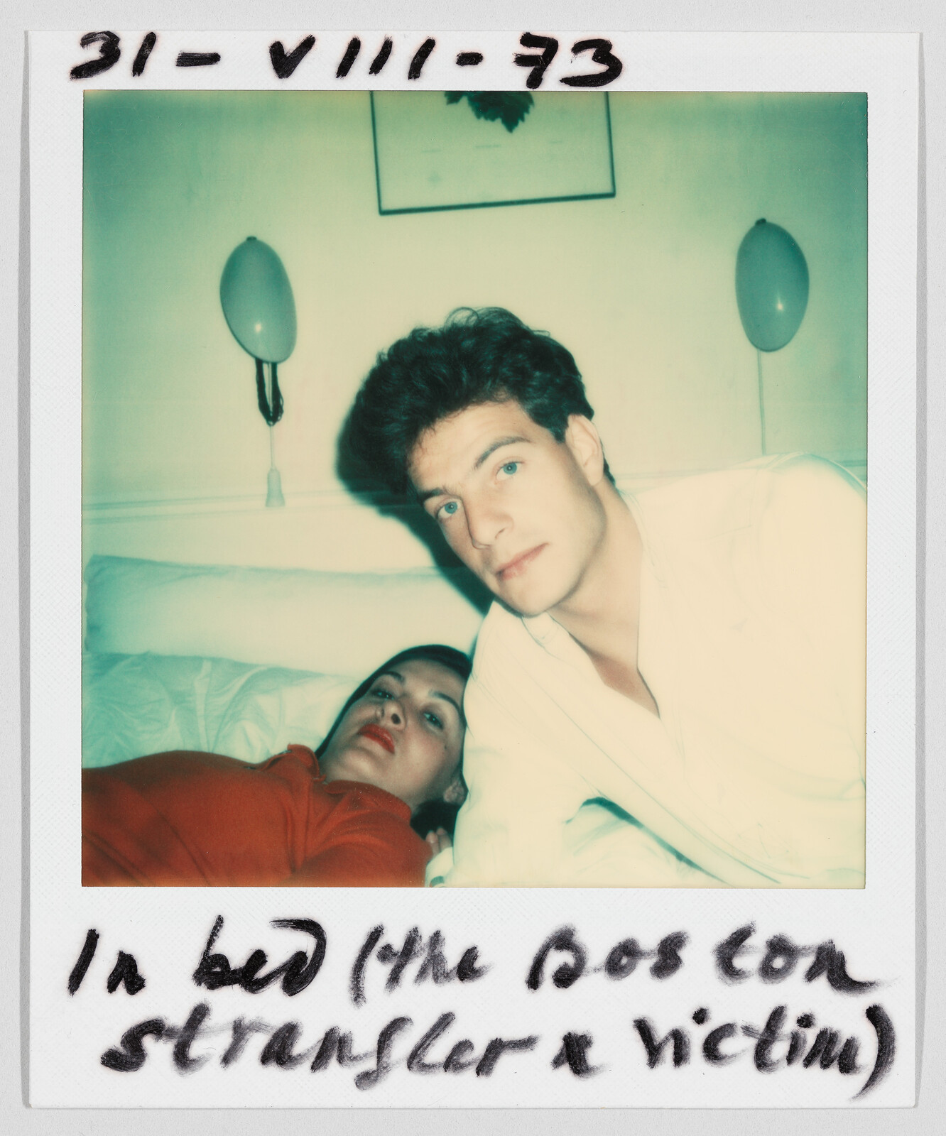 A man and woman lie on a bed; handwritten text reads “In bed (the Boston Strangler x victim).”