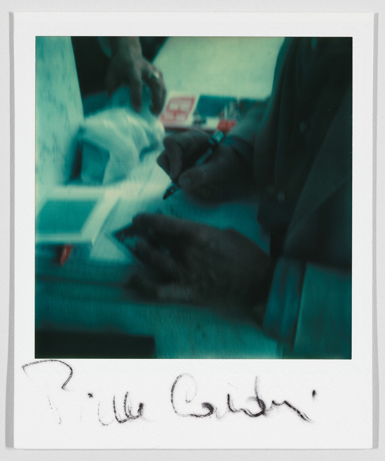 A person signs an autograph with a pen; the name "Billie Corbin" is written at the bottom.