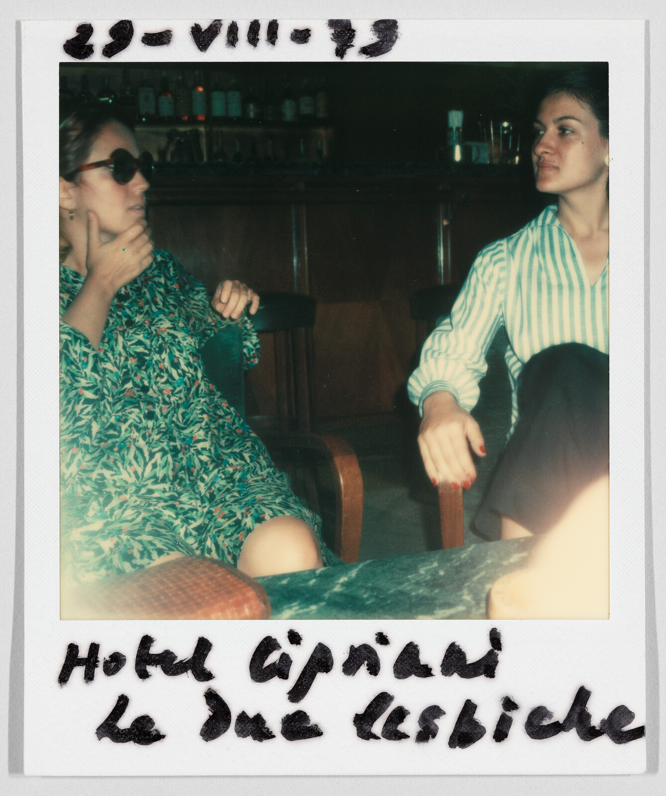 Two women sit and talk in a bar. Handwritten text reads: "Hotel Cipriani le due lesbiche."