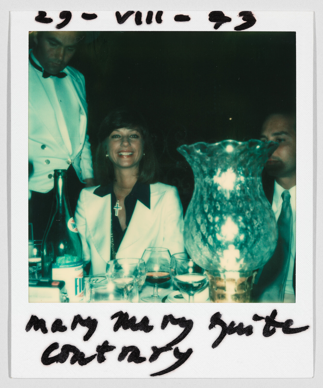 A woman in a white suit smiles at a dinner table; handwritten text reads "mary mary quite contrary."