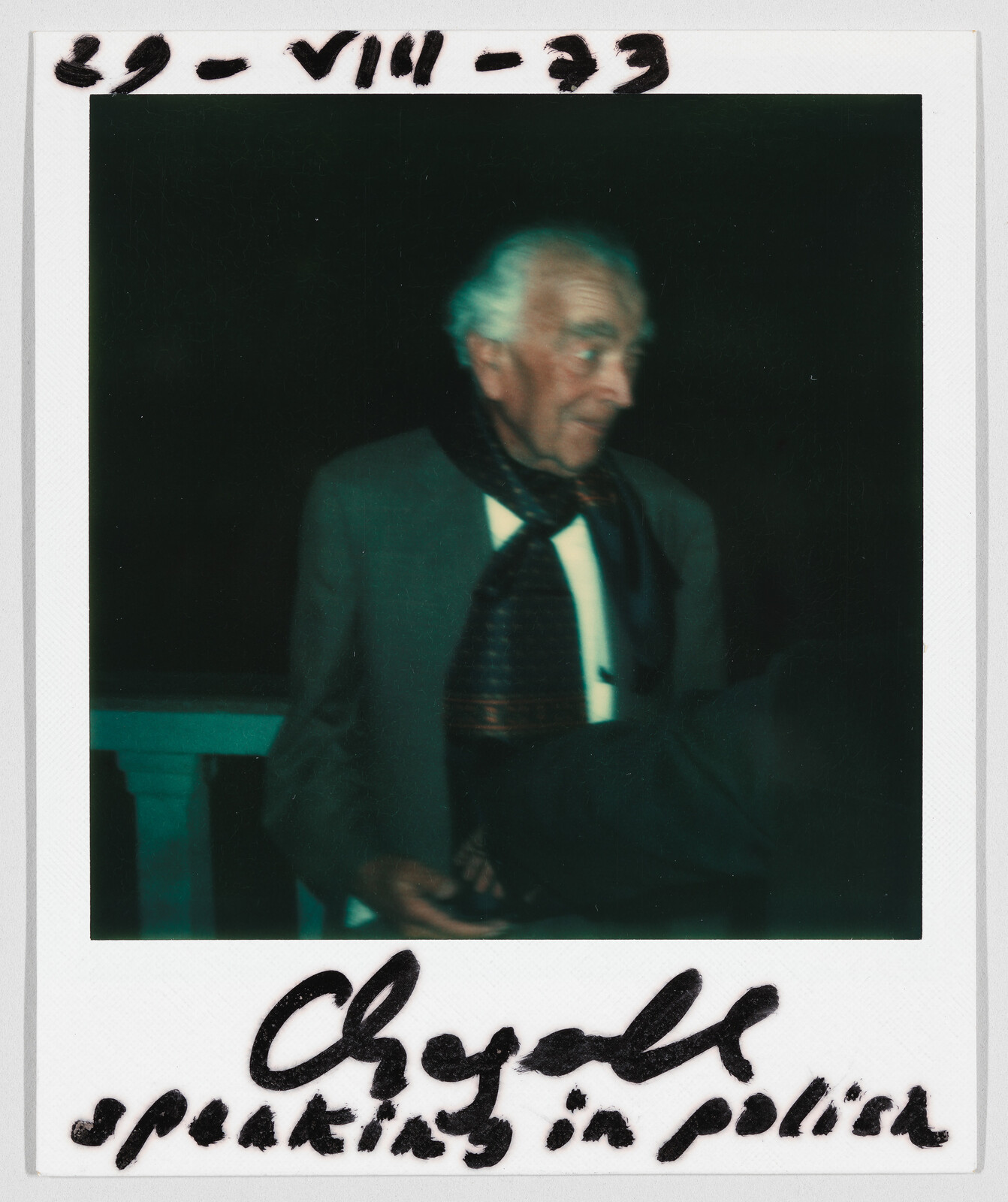An older man in a suit and scarf stands at night; handwritten text reads “Chagall speaking in polish.”