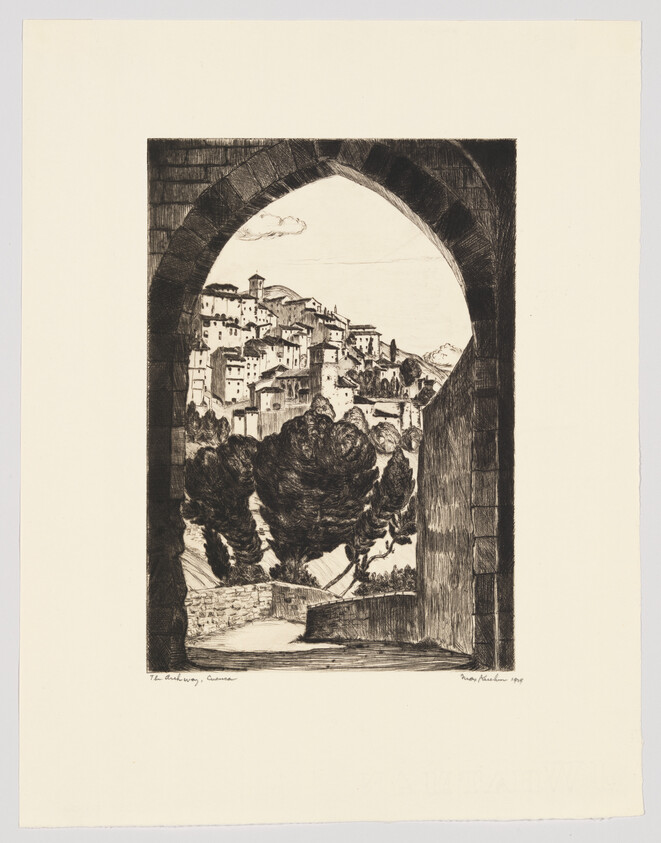 Stone archway frames a hillside village with clustered houses and tall trees in the foreground.