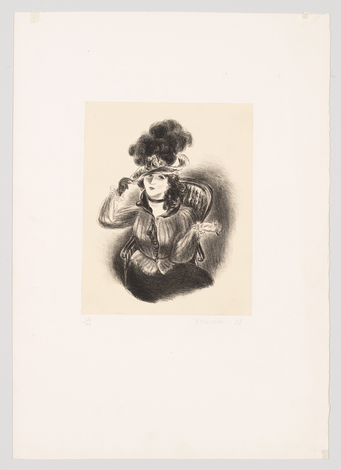 A seated woman in a large feathered hat adjusts the brim while resting in a chair.