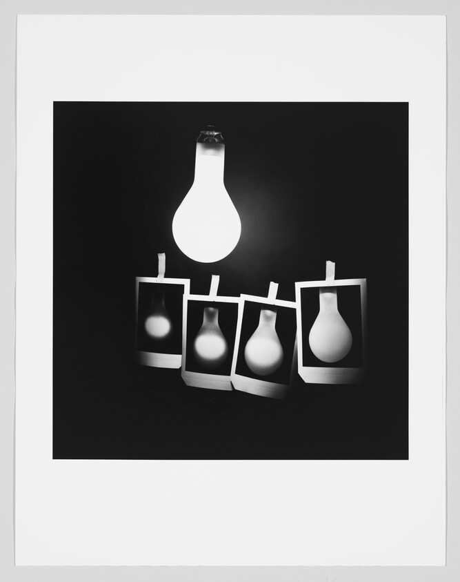 A glowing light bulb hangs above four taped Polaroid photos showing different bulb silhouettes.