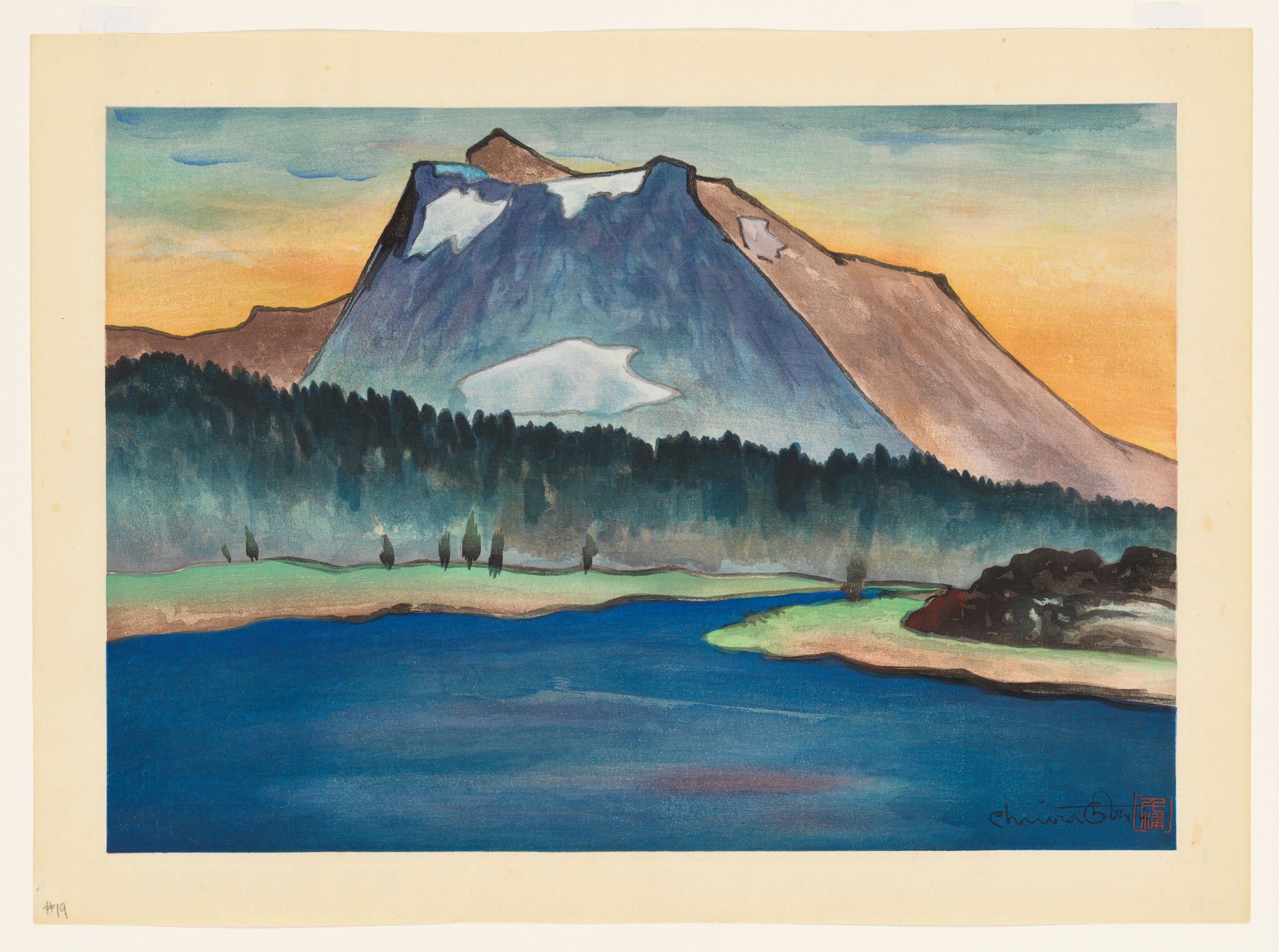 A large mountain with snow patches rises above a dark forest beside a calm blue lake.