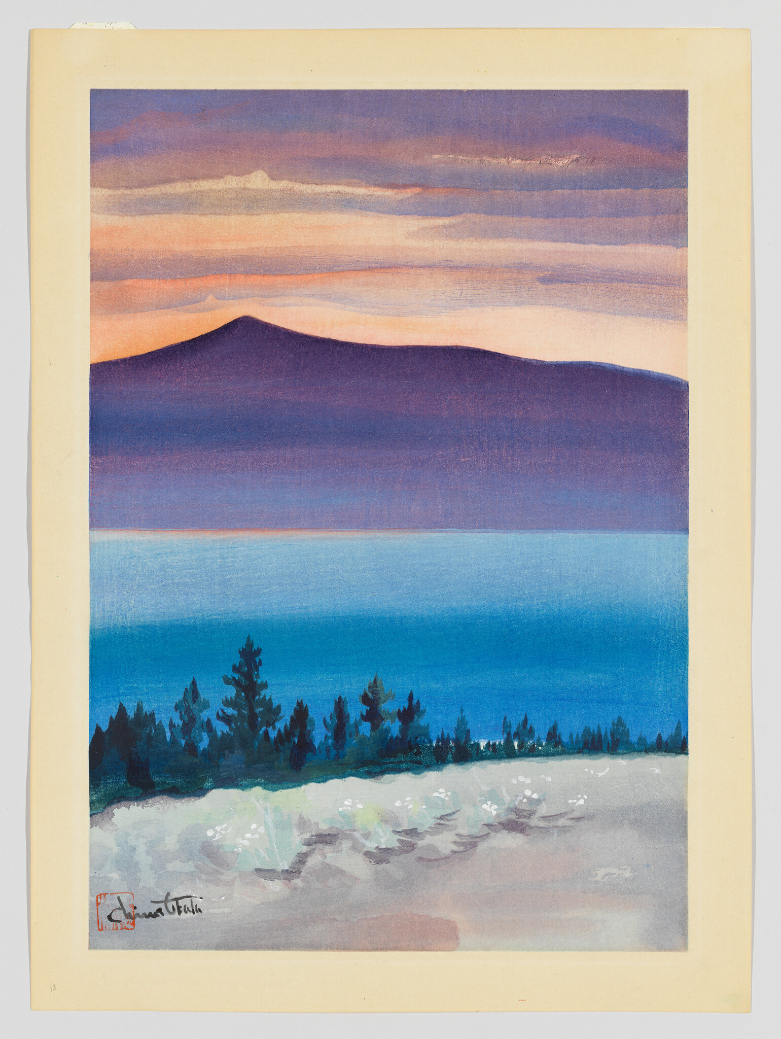 A purple mountain silhouette rises above calm blue water with trees and a sandy foreground.