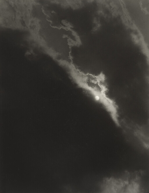Bright sun peeks through a jagged seam of clouds against a dark sky.