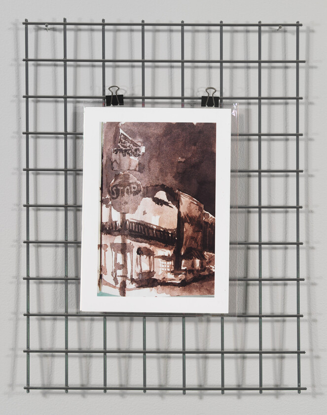 A monochromatic watercolor painting depicting an architectural scene is displayed on a gray wall, held by two black clips at the top and mounted on a metal grid structure.