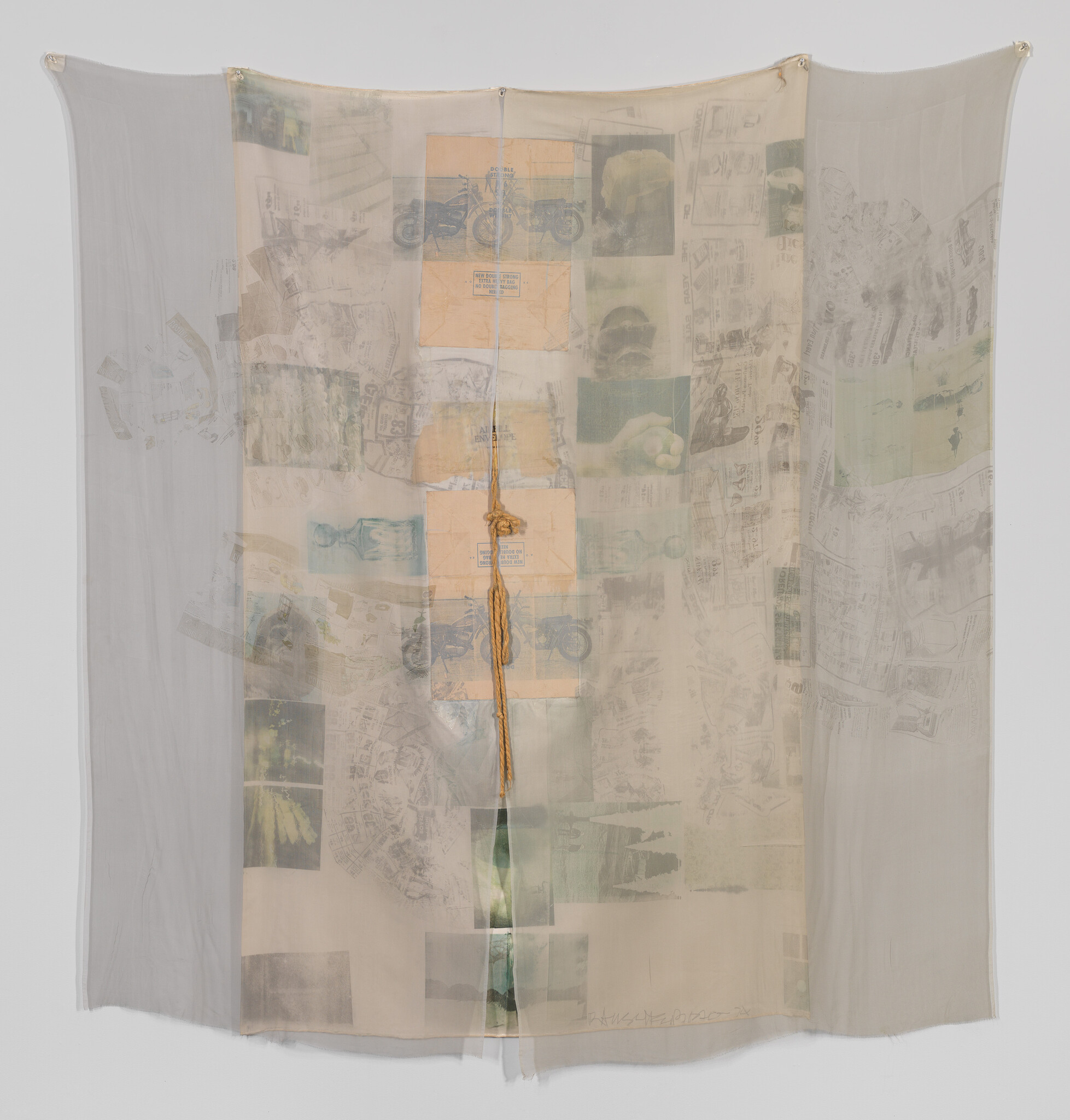 Sheer fabric panel hangs with printed images and a knotted rope running down its center.