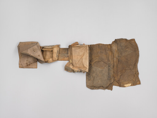 Worn, patched canvas and burlap sacks arranged flat with folded pockets and faint stenciled text.