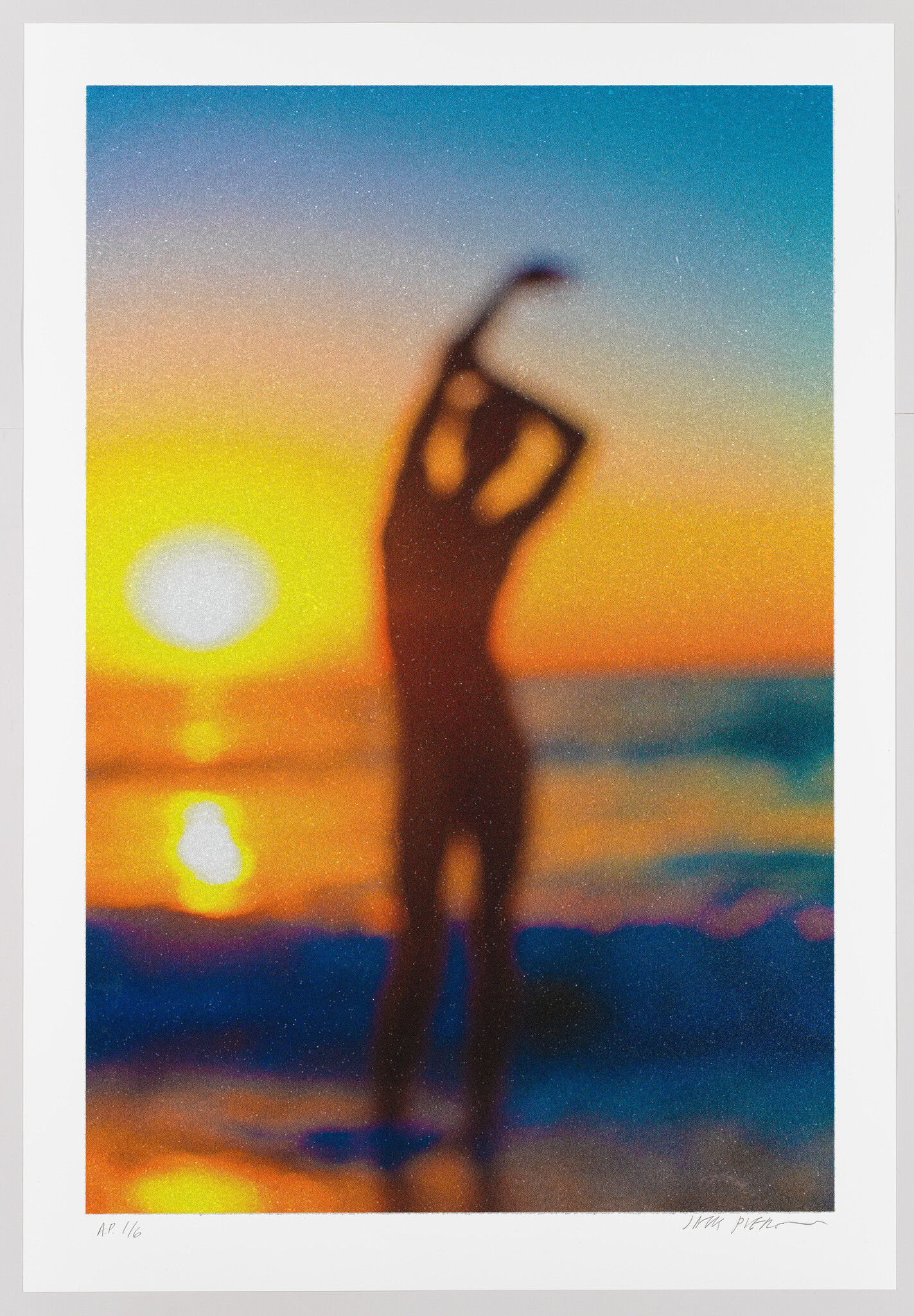 Silhouette of a person stretching on the beach as the sun sets over the water.