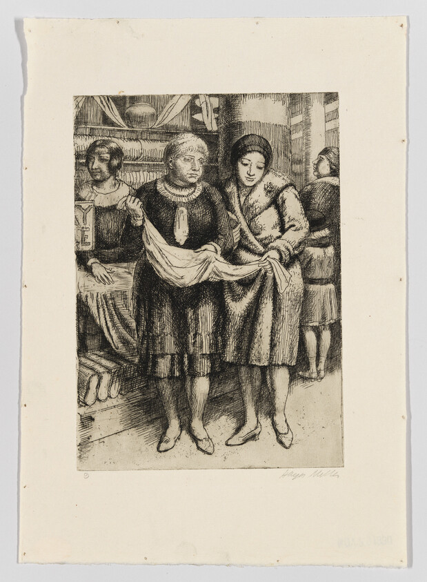 Two women stand in a shop holding and inspecting a length of cloth together.