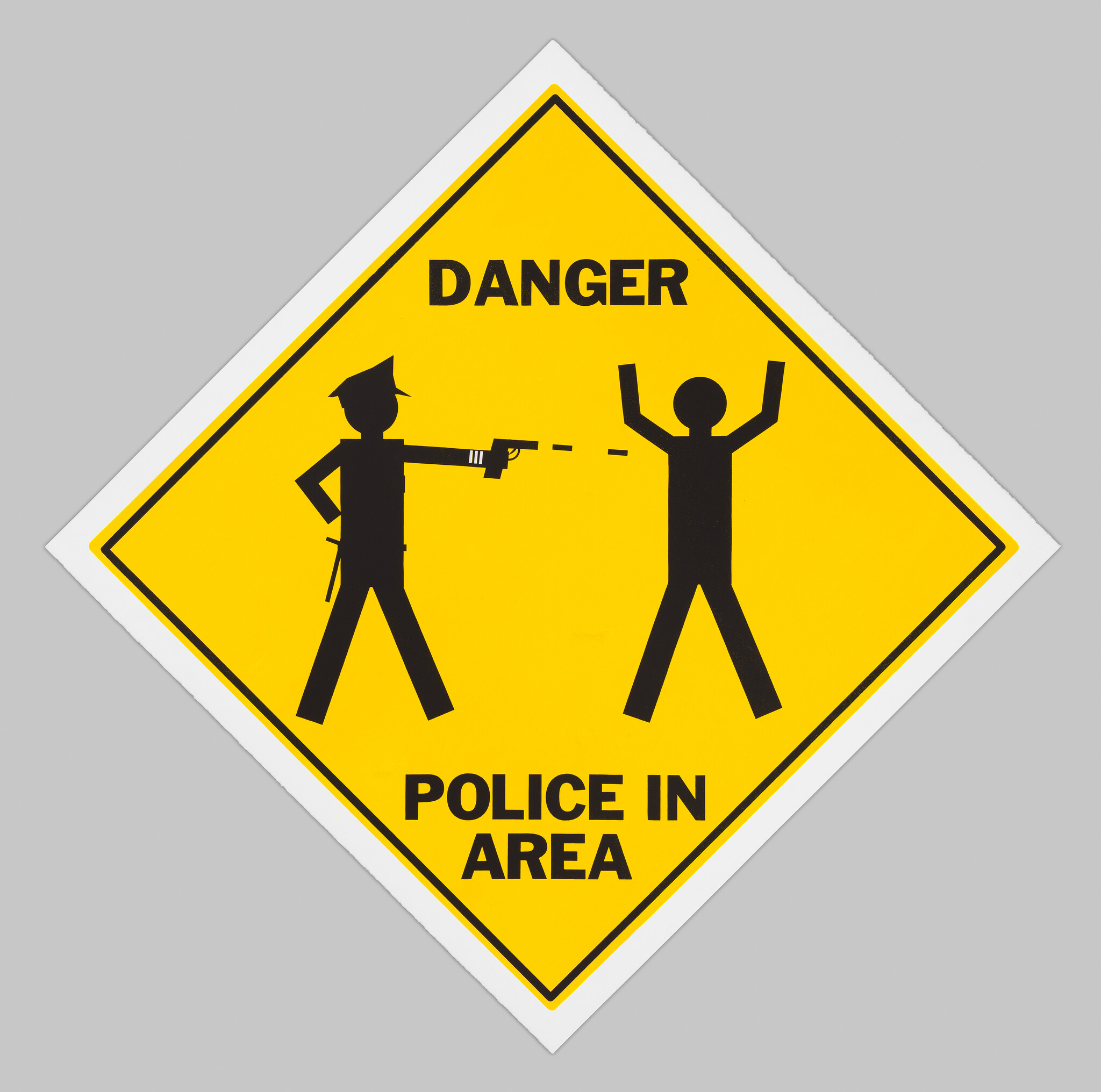 Yellow diamond sign reading Danger Police in area showing a police officer pointing a gun at a person.