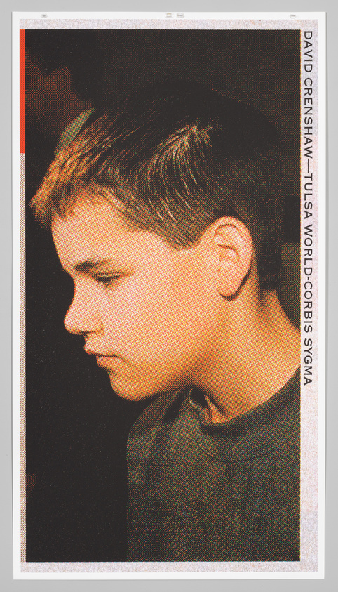 A young boy with short hair looks down, wearing a dark shirt. The image has a grainy texture.