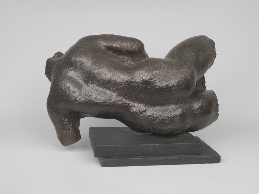 Bronze abstract reclining human torso sculpture resting on a two-tier rectangular base.