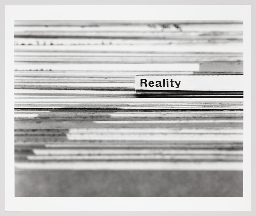 A stacked set of index cards with a tab labeled Reality sticking out among them.