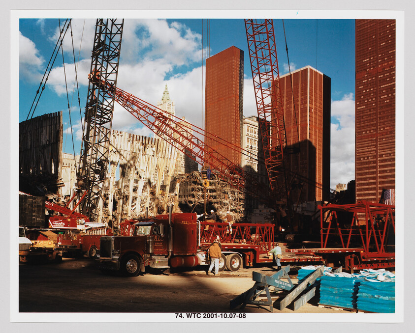 Cranes and trucks remove rubble at the World Trade Center site while workers coordinate operations.