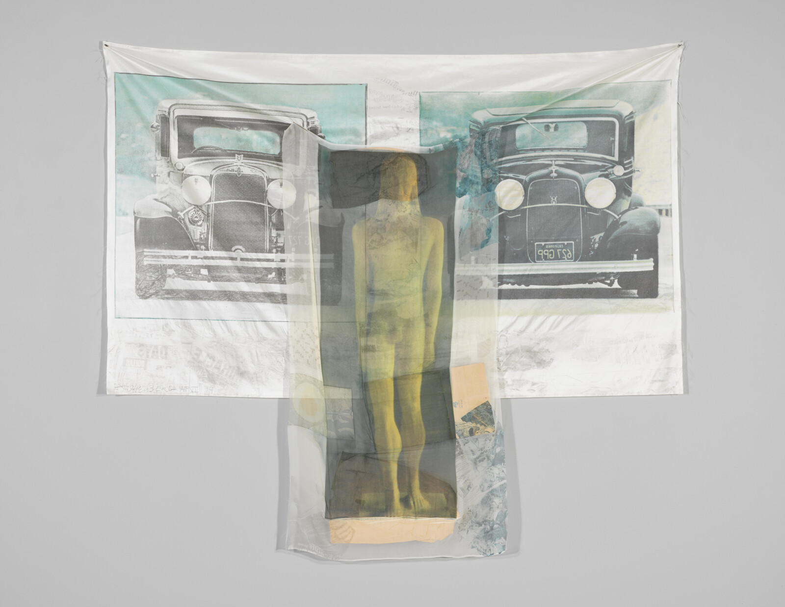 A translucent fabric with a yellow standing figure overlays a printed cloth showing two vintage cars.