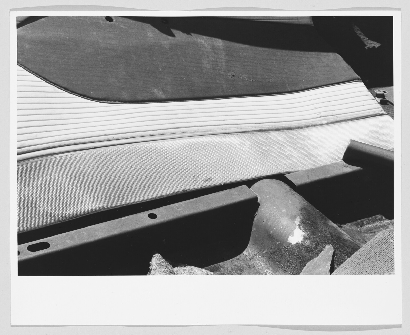 Worn car bench seat and rear interior panels with visible stains and torn upholstery.