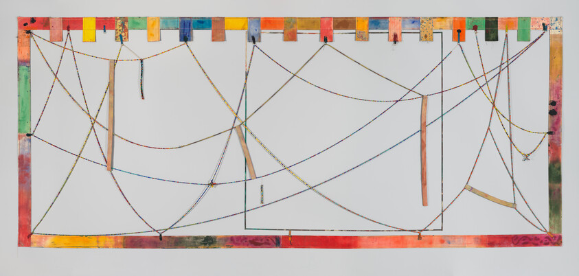 A colorful rectangular frame with strings and ribbons stretched and hanging in various directions across the open space.
