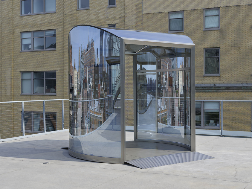 A structure made up of tinted plexiglass with slightly curved walls and an opening in front.