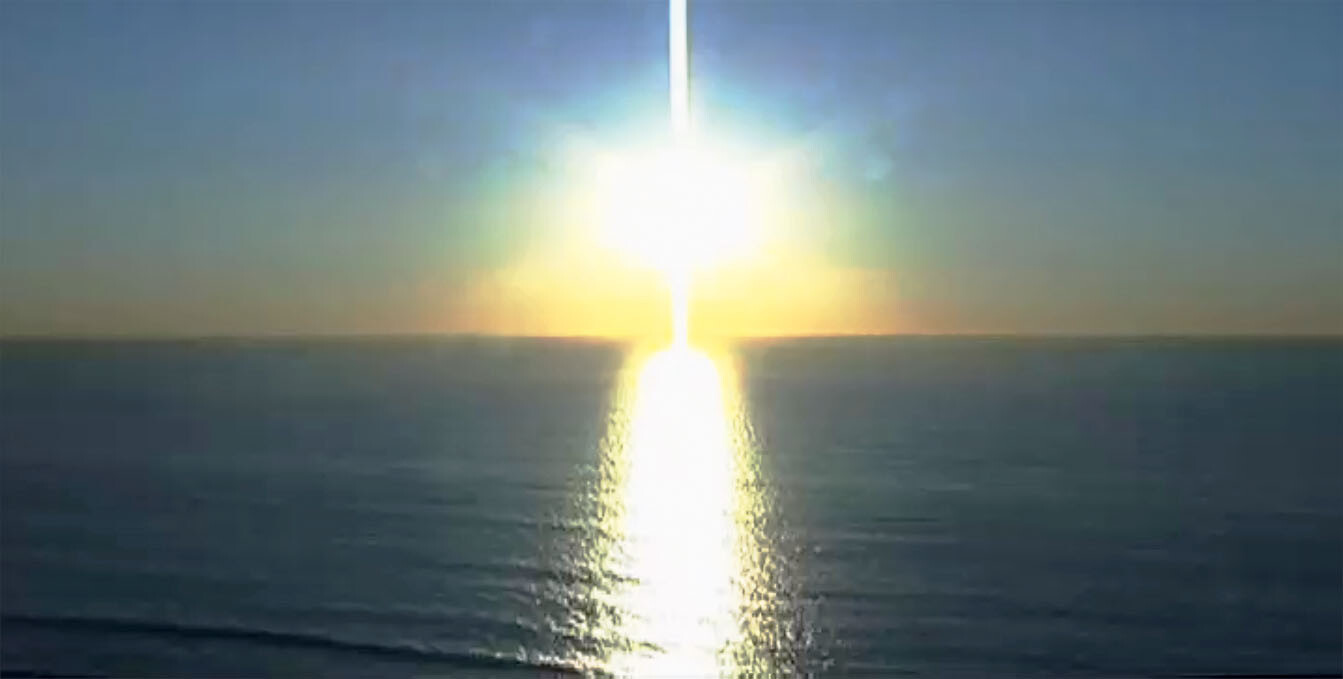Bright sun low over the ocean, with sunlight reflecting in a straight line across the water.